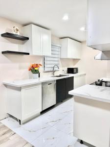 uma cozinha branca com armários brancos e um vaso de flores em Bedroom 1 with free Parking, free wi-fi and shared washroom (Room 1) em Kitchener