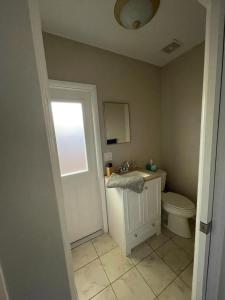 a bathroom with a toilet and a sink and a window at Quaint Guest Room Close to Siesta Key in Sarasota
