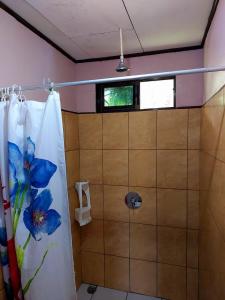 a bathroom with a shower with a blue flower shower curtain at Chinitas Eco Lodge in Tortuguero