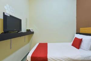 a hotel room with a bed and a tv at Dimensi Hotel in Kampong Alor Gajah