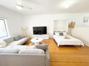 a living room with a couch and a tv at The Scarborough Beach House - Walk to the beach! in Perth