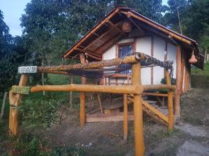 uma pequena casa de madeira com rede em El Refugio del Oso de Anteojos em Fómeque