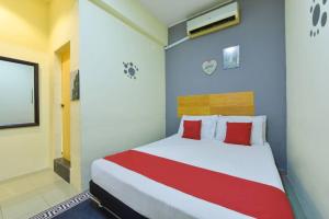 ein Schlafzimmer mit einem großen Bett mit roten Kissen in der Unterkunft Dimensi Hotel in Kampong Alor Gajah + 6 Fotos