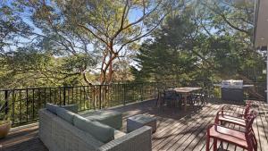 CopacabanaTreetops At Copacabana Accom Holidays的甲板上配有沙发、椅子和桌子