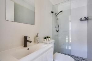 a white bathroom with a sink and a shower at 3 Bedroom House Chippendale Near the Center 2 E-Bikes Included in Sydney