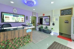 ein Wartezimmer mit lila Wänden und einer Theke in der Unterkunft Dimensi Hotel in Kampong Alor Gajah
