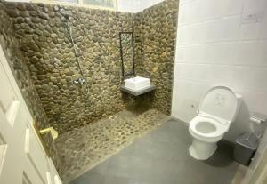 a bathroom with a toilet and a walk in shower at Sentosa Lodge in Kampungdurian