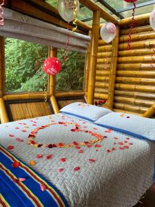 a bedroom with a bed with red confetti on it at El Refugio del Oso de Anteojos in Fómeque