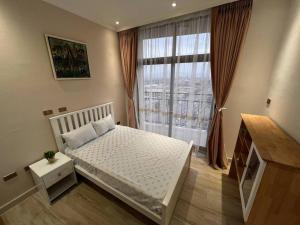 - une chambre avec un lit blanc et une grande fenêtre dans l'établissement Spacious 2 BR apartment near the airport, à Addis-Abeba