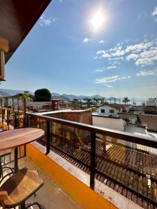 uma varanda com uma mesa e uma vista em Pousada Amanhecer do Itaguá em Ubatuba