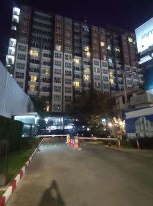 a parking lot in front of a large building at night at The Prio Condo in Chiang Mai