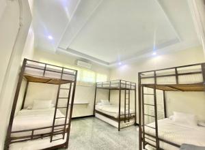 two bunk beds in a room with white walls at Sentosa Lodge in Padang