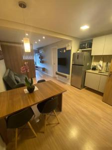 a kitchen and dining room with a table and chairs at Loft Flow Parque Una com garagem! in Pelotas