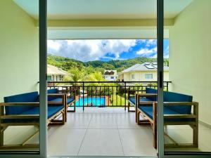 a balcony with chairs and a view of a pool at The Seaboards Apartments Seychelles in Mahe
