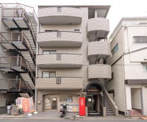 東京的住宿－KYARA Hotelミスミ301，公寓大楼的一侧设有螺旋阳台