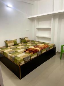 uma cama grande num quarto branco com um visor de cama em Garuda Guest House em Varanasi