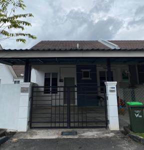a blue and white house with a gate at Razumi's Homestay in Arau