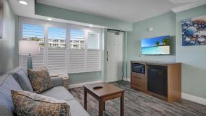 een woonkamer met een bank en een tv bij Boardwalk Inn and Suites in Daytona Beach