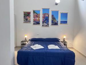 1 dormitorio blanco con 1 cama azul y 2 mesitas de noche en 8 Lofts - Apartments, en La Spezia