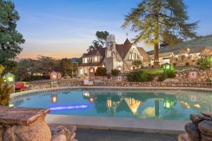 a home with a swimming pool in front of a house at The Magic Castle (Unit5) - Six Flags in Newhall