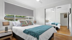 een slaapkamer met een groot bed en een spiegel bij New With A View Accom Holidays in Copacabana