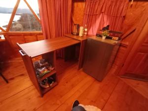 Habitación con escritorio de madera y nevera. en Domos lago Muisca Xue, en Aquitania