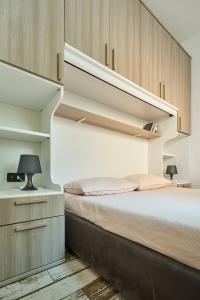 - une chambre avec un lit et des placards en bois dans l'établissement appartamento a due passi dal mare, à Bellaria-Igea Marina