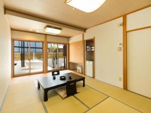 een woonkamer met een tafel in een kamer bij Yuraku Hotel in Awara
