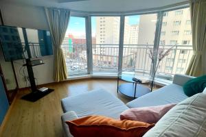 uma sala de estar com um sofá e uma grande janela em AMS TOWER 806 em Sapporo