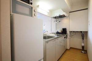 a kitchen with white cabinets and a sink at AMS TOWER 806 in Sapporo