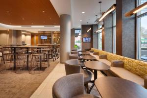 een bar met tafels en stoelen in een restaurant bij SpringHill Suites by Marriott Coralville in Coralville