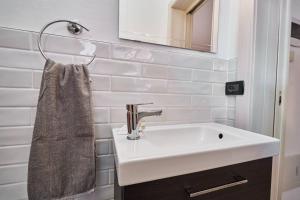 une salle de bain blanche avec un lavabo et un miroir dans l'établissement appartamento a due passi dal mare, à Bellaria-Igea Marina 120 autres photos