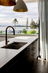 a kitchen with a sink and a large window at Balmoral on Scott - Harbour Front Perfection in Newcastle