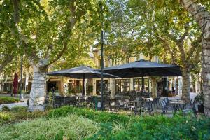 un groupe de tables et de chaises avec parasols dans l'établissement appartamento a due passi dal mare, à Bellaria-Igea Marina