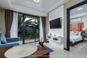 a bedroom with a bed and a tv and a couch at Modern MBC condo near the beach in Ban Bo Sai Klang