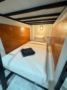 un piccolo letto con una camicia nera seduta sopra di Journey Hostel Haad Rin a Haad Rin