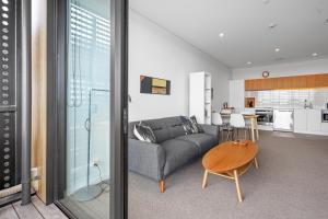 a living room with a couch and a table at Urban Vista - Christchurch Holiday Home in Christchurch