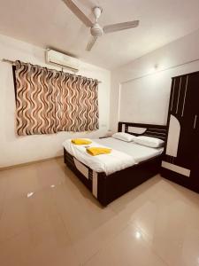 een slaapkamer met een bed en een raam erin bij Namaste Nirvana Appartments in Daman