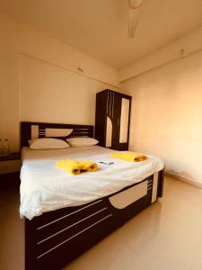 una camera da letto con un grande letto con asciugamani gialli di Namaste Nirvana Appartments a Daman