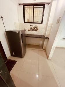 a bathroom with a toilet in a room with a window at Namaste Nirvana Appartments in Daman