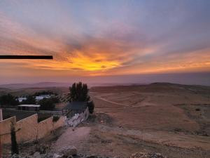 un coucher de soleil depuis le sommet d'une colline dans l'établissement Al Namteh Lodge, à ‘Ābil