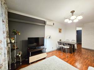 a living room with a flat screen tv and a table at Nadezhda Apartments on Nayryzbay batyr 82 in Almaty