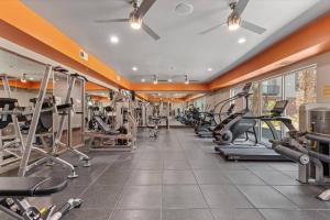 a gym with several treadmills and elliptical machines at Stylish and Cozy in Dallas Downtown in Dallas