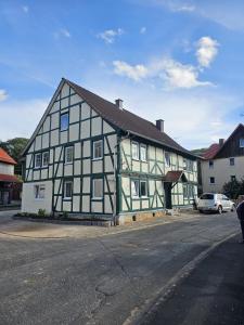 a black and white building with a car parked in front of it at Gästehaus Reimold in Bebra