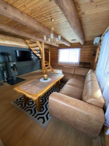 ein Wohnzimmer mit einem Sofa und einem Tisch in der Unterkunft Soosaare Holiday House in Nasva