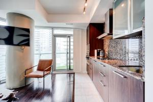 una cocina con armarios de madera y una silla. en Downtown Toronto APT, en Toronto