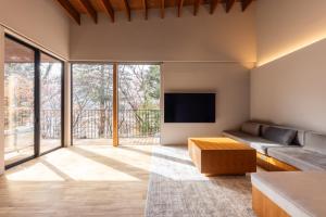 a living room with a couch and a flat screen tv at Hotarutei Villas in Yamanouchi +77 photos