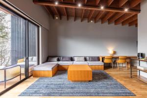 uma sala de estar com um sofá e uma mesa em Hotarutei Villas em Yamanouchi