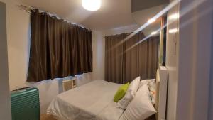 - une chambre dotée d'un lit avec un oreiller vert dans l'établissement Condo unit 2 Bedroom one oasis fullyfurnished, à Davao