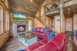 a living room with a red couch and a fireplace at Freedoms View, Game Room & Amazing Views, FREE tickets each paid day, Hot Tub!!! in Sevierville